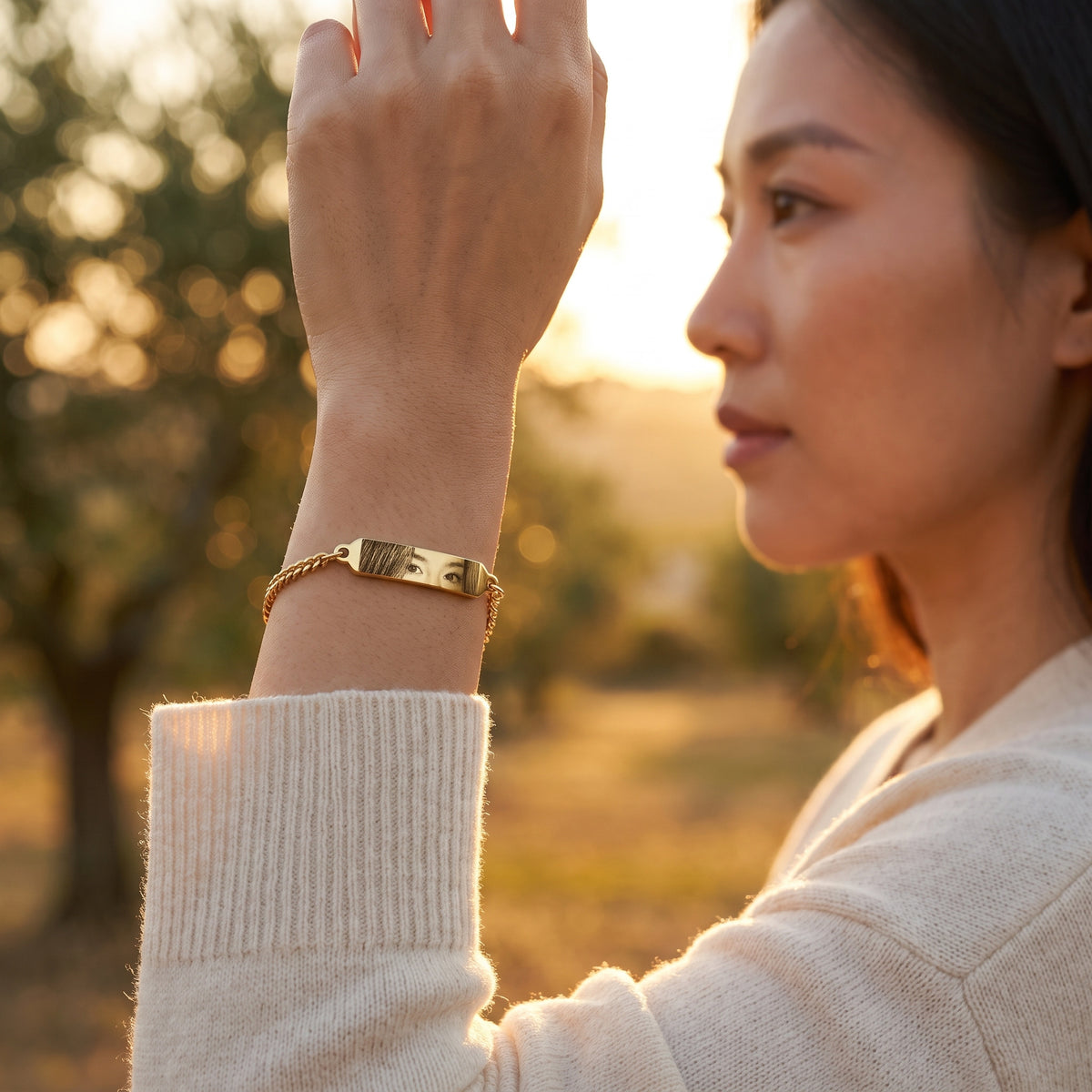 Frau trägt das goldene Augen-Armband mit Foto-Gravur