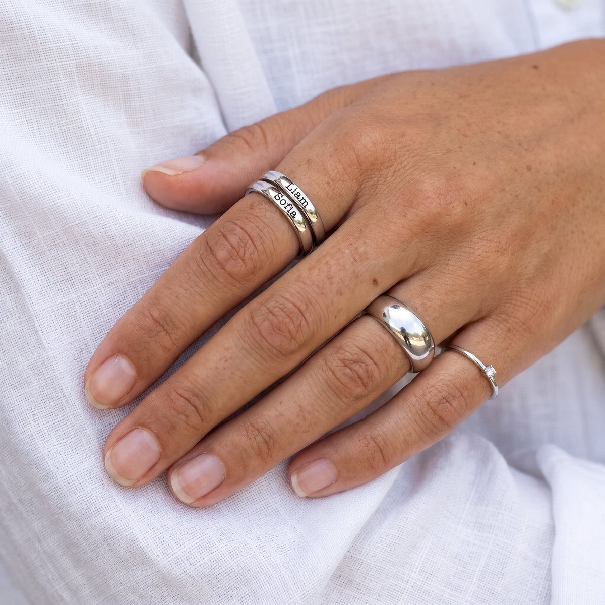 Stapelring mit Namen – Silber – mit anderen Ringen kombiniert, getragen, Nahaufnahme